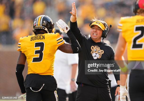 Luther Burden III of the Missouri Tigers celebrates head coach Eliah Drinkwitz after scoring a touchdown during the first half against the Vanderbilt...