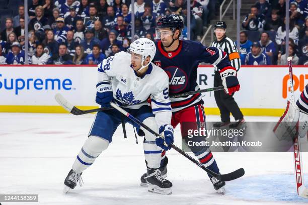 Michael Bunting of the Toronto Maple Leafs battles Neal Pionk of the Winnipeg Jets in front of the net during first period action at the Canada Life...