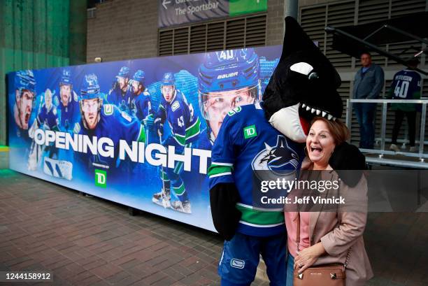 Vancouver Canucks mascot Fin playfully bites the head of a fan before the Canucks NHL game against the Buffalo Sabres at Rogers Arena October 22,...