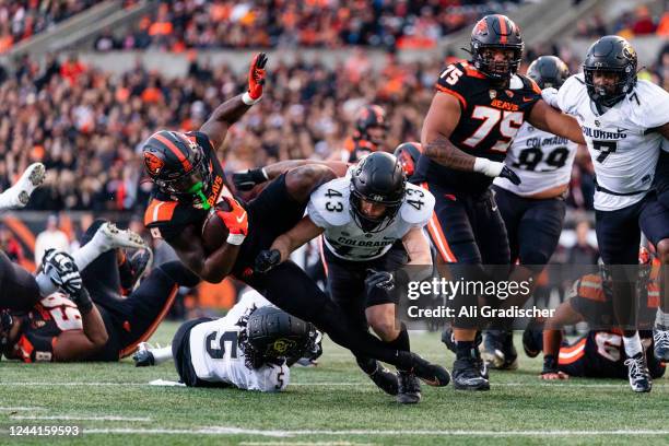 Running back Jam Griffin of the Oregon State Beavers gets tackled by Safety Trevor Woods of the Colorado Buffaloes during the first half of the game...