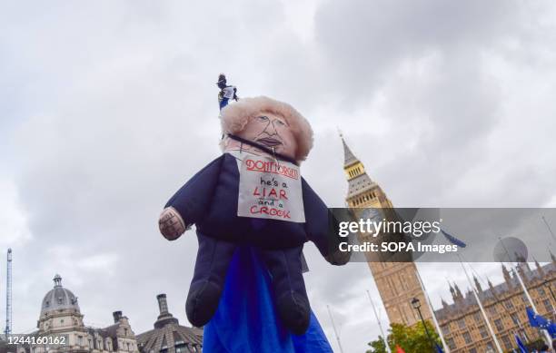 Boris Johnson doll with a sign calling the former UK Prime Minister a "liar' and a "crook" is seen during the demonstration in Parliament Square....