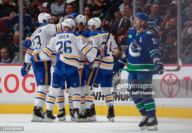 Oliver Ekman-Larsson of the Vancouver Canucks looks on dejected as Alex Tuch of the Buffalo Sabres is congratulated by teammates after scoring during...