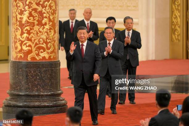 China's President Xi Jinping walks with members of the Chinese Communist Party's new Politburo Standing Committee, the nation's top decision-making...