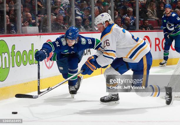 Vasily Podkolzin of the Vancouver Canucks checks Rasmus Dahlin of the Buffalo Sabres during their NHL game at Rogers Arena October 22, 2022 in...