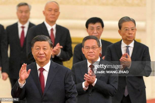 China's President Xi Jinping walks with members of the Chinese Communist Party's new Politburo Standing Committee, the nation's top decision-making...