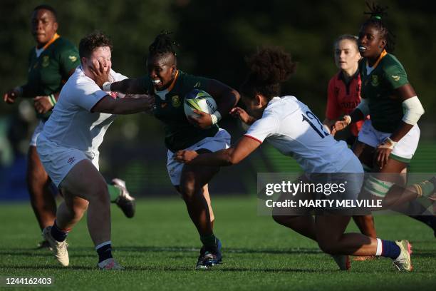 South Africa's Lusanda Dumke is tackled by England's Hannah Botterman and Tatyana Heard during the New Zealand 2021 Womens Rugby World Cup Pool C...