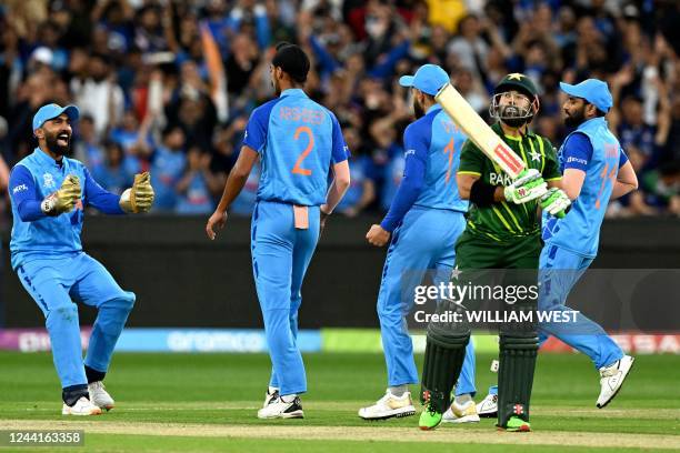 India's Dinesh Karthik greets India's Arshdeep Singh as Pakistan's Mohammad Rizwan walks off the field after his dismissal during the ICC men's...