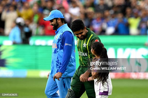 Pakistan's Captain Babar Azam and India's captain Rohit Sharma walk into the ground during the ICC men's Twenty20 World Cup 2022 cricket match...
