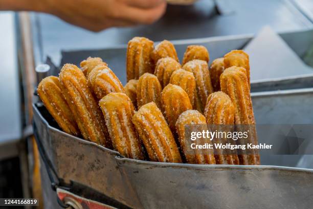 Street vendor is selling Churros in downtown Oaxaca de Juarez, Oaxaca, Mexico.