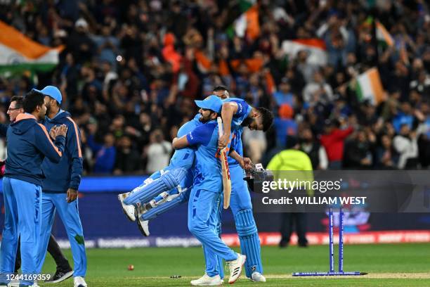 India's Captain Rohit Sharma lifts Virat Kohli as they celebrate after a win during the ICC men's Twenty20 World Cup 2022 cricket match between India...