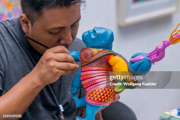 Alibrije - carved, colorful painted animals and fantasy creatures - being painted at the alibrije studio of Jacobo y Maria Angeles in the Zapotec...