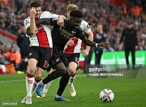 Arsenal's English midfielder Bukayo Saka vies with Southampton's French defender Romain Perraud during the English Premier League football match...