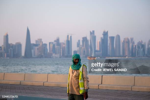 Worker walks along a marina in Doha on October 23 ahead of the Qatar 2022 FIFA World Cup football tournament.