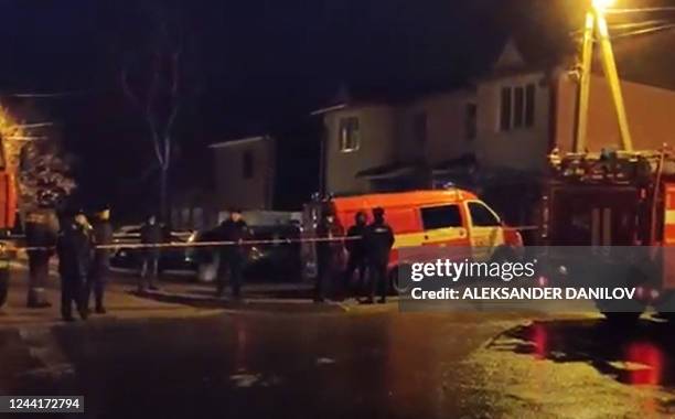 Picture taken late on October 23 shows emergency personnel working at the crash site of a military jet in a residential area in Irkutsk, Siberia,...