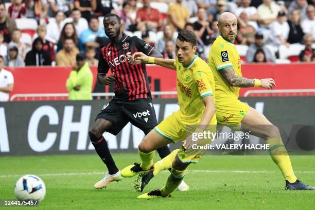 Nice's Ivorian forward Nicolas Pepe fights for the ball with Nantes' Brazilian defender Andrei Girotto and Nantes' French defender Nicolas Pallois...