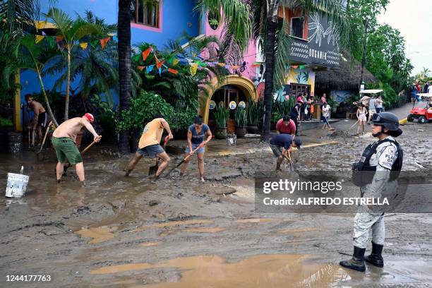 People clean the streets after the arrival of Hurricane Roslyn in Sayulita community, Nayarit State, Mexico, on October 23, 2022. - Hurricane Roslyn...