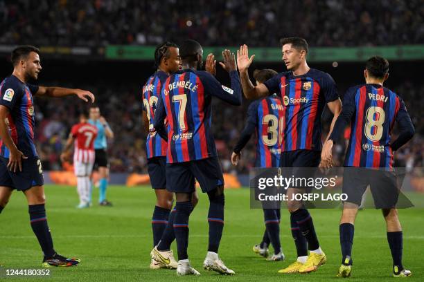 Barcelona's French forward Ousmane Dembele celebrates with Barcelona's Polish forward Robert Lewandowski scoring his team's first goal during the...