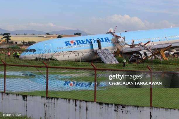 The plane of Korean Air flight KE631 lies with its belly on the runway at the airport in Cebu City, central Philippines on October 24 after it...
