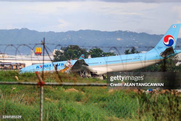 The plane of Korean Air flight KE631 lies with its belly on the runway at the airport in Cebu City, central Philippines on October 24 after it...