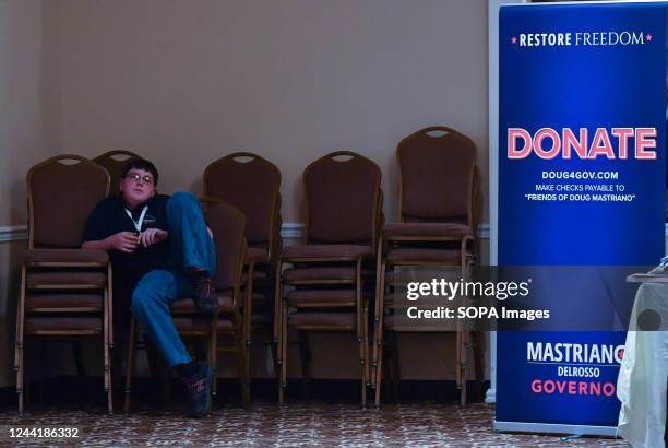 Young boy rests on a stack of chairs at a Doug Mastriano rally. Republican Candidate for Pennsylvania Governor Doug Mastriano made campaign stops in...