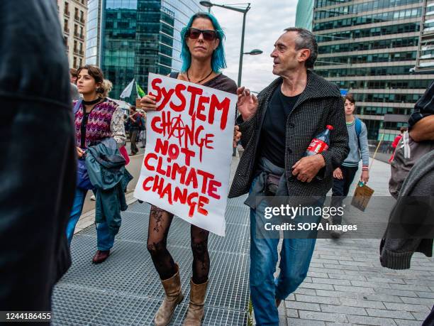 Protester holds a placard against capitalism during the climate change demonstration march. Thousands of people gathered at the Brussels North...