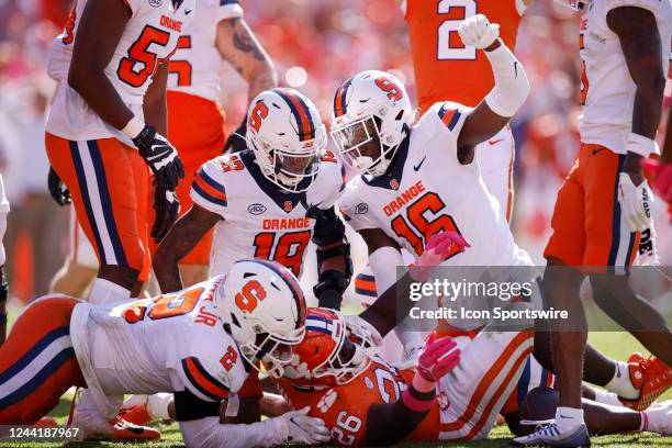 Syracuse Orange linebacker Leon Lowery , defensive back Rob Hanna and linebacker Marlowe Wax make a tackle against Clemson Tigers running back Phil...