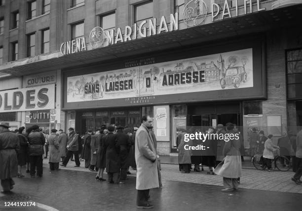 People stand in front of the Cinema Pathé Marignan on the Champs Elysées Avenue in Paris, in January 1951 where the film "Sans laisser d'adresse",...