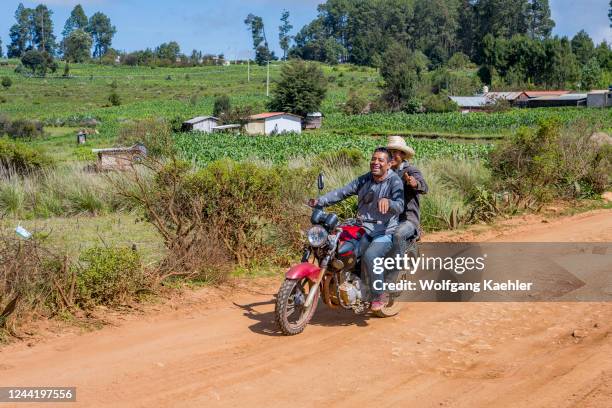 Men on a motor bike on a dirt road in the mountains west of Oaxaca City, Mexico.