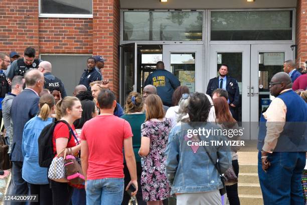 St. Louis metropolitan police and school officials stand outside the south entrance to the Central Visual and Performing Arts High School after a...