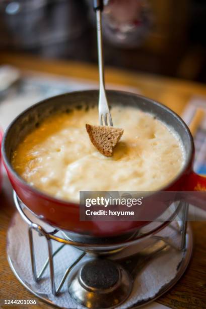 fondue de queso suizo en la mesa del comedor - molten fotografías e imágenes de stock