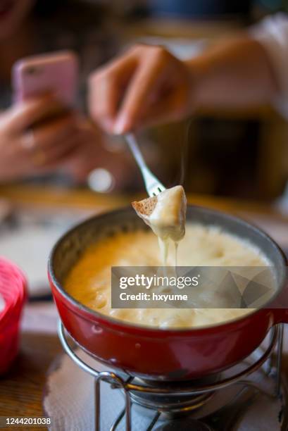 schweizer käsefondue auf esslichem tisch - fondue stock-fotos und bilder