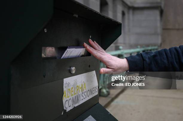 Voter casts their ballot at a drop box is displayed outside Philadelphia city hall on October 24, 2022. - Philadelphia's 18 secure mail ballot drop...