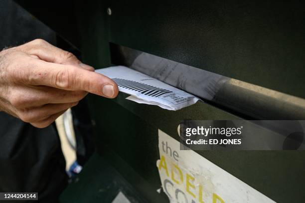 Voter casts their ballot at a drop box is displayed outside Philadelphia city hall on October 24, 2022. - Philadelphia's 18 secure mail ballot drop...