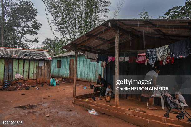 Family stands in front of their house at Tekoha Marangatu Guarani indigenous village in the municipality of Guaira, Parana state, Brazil, on October...