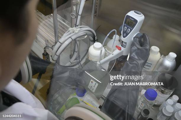 Scientist of Y-TEC handles a lithium cell in Berisso, Buenos Aires province, on October 18, 2022. - With 19 million tons, Argentina is, after...