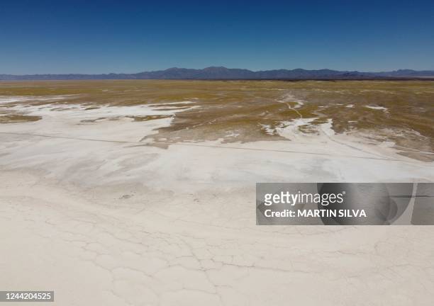 Aerial view of the Salinas Grandes salt flat meeting the arid desert plain near the Kolla indigenous community of Santuario de Tres Pozos, which in...