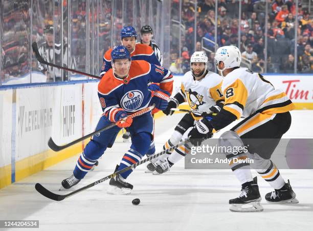 Zach Hyman of the Edmonton Oilers chases the puck against Brian Dumoulin of the the Pittsburgh Penguins during the game on October 24, 2022 at Rogers...