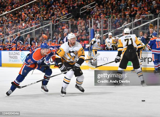 Connor McDavid of the Edmonton Oilers battles for the puck against Jeff Carter of the Pittsburgh Penguins during the game on October 24, 2022 at...