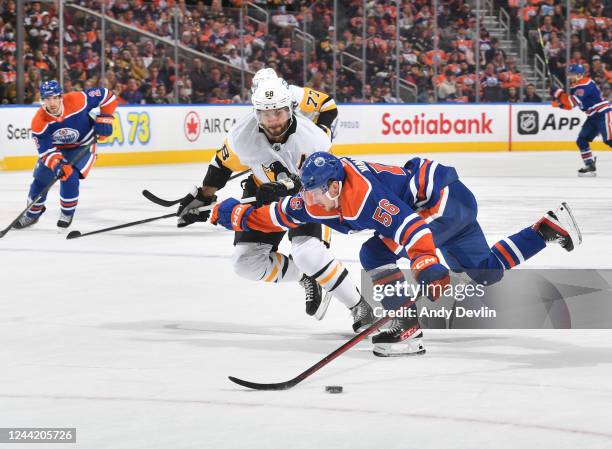 Kailer Yamamoto of the Edmonton Oilers skates with the puck against Kris Letang of the Pittsburgh Penguins during the game on October 24, 2022 at...