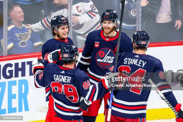 Morgan Barron, Sam Gagner, Adam Lowry and Logan Stanley of the Winnipeg Jets celebrate a third period goal against the St. Louis Blues at the Canada...