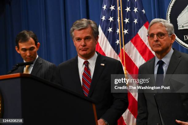 Director Christopher Wray, center, and U.S. Attorney General Merrick B. Garland, right, pause during a press conference to discuss significant...