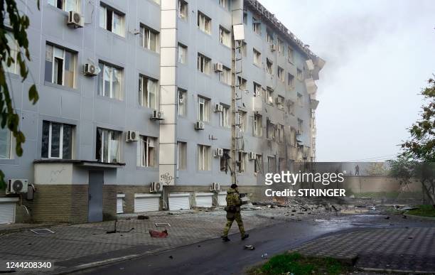 Serviceman guards the site of a car bomb explosion outside a building housing a local TV station in the Russian-held city of Melitopol in southern...