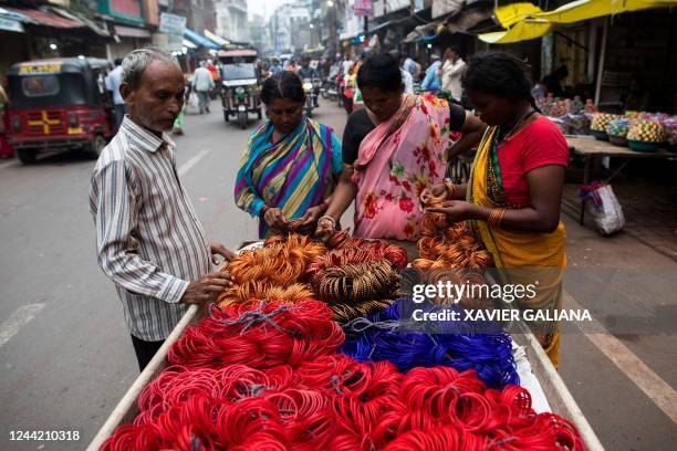 In this picture taken on October 12 women browse through glass bangles at a bangle wholesale market in Firozabad. - The Indian industrial town of...