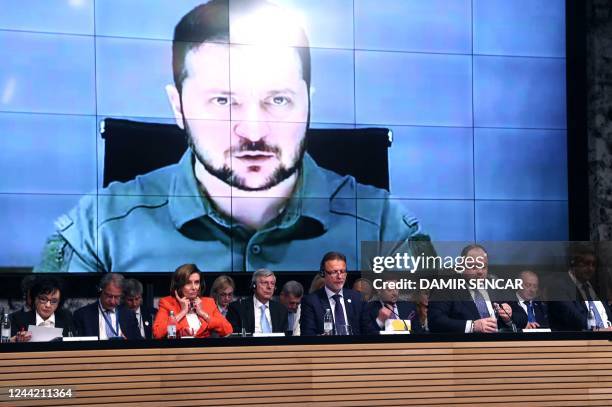 Ukraine's President Volodymyr Zelenskyy appears on screens as he speaks via a video link at the opening session of the International Crimea Platform...