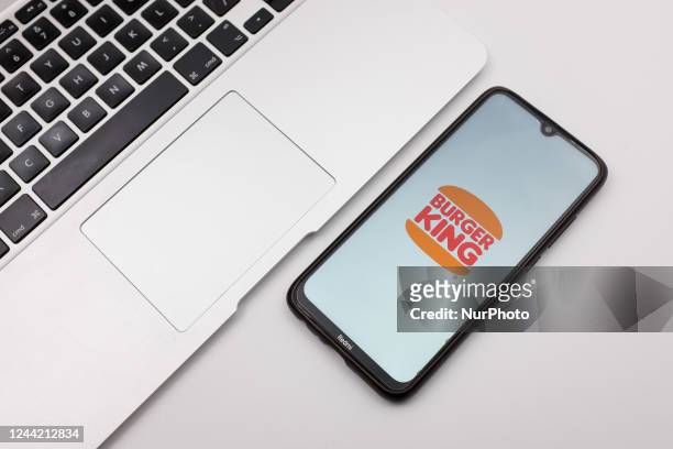In this photo illustration a Burger King logo seen displayed on a smartphone screen on a desk next to a Macbook in Athens, Greece on October 25, 2022.