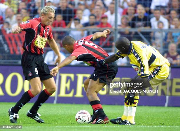 Nice's striker Lilian Laslandes and his teammate Brazilian midfielder Peira da Silva Everson fight for the ball with Sochaux's Senegalese defender...