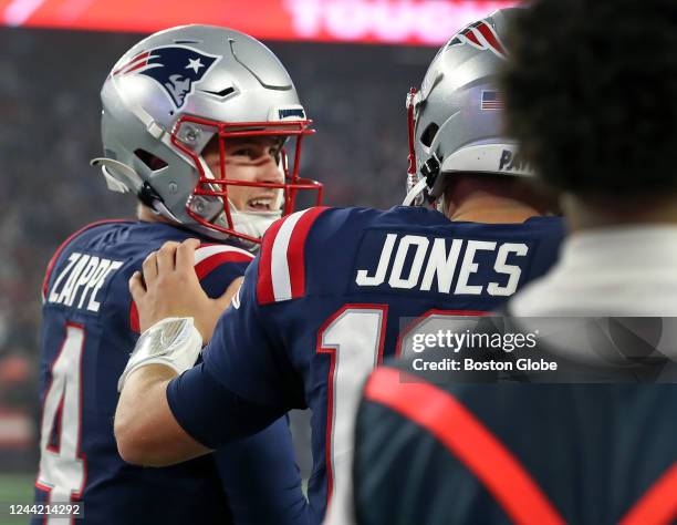 Foxborough, MA New England Patriots QB Mac Jones gives fellow QB Bailey Zappe a pat on the back following a scoring drive engineered by Zappe. The...