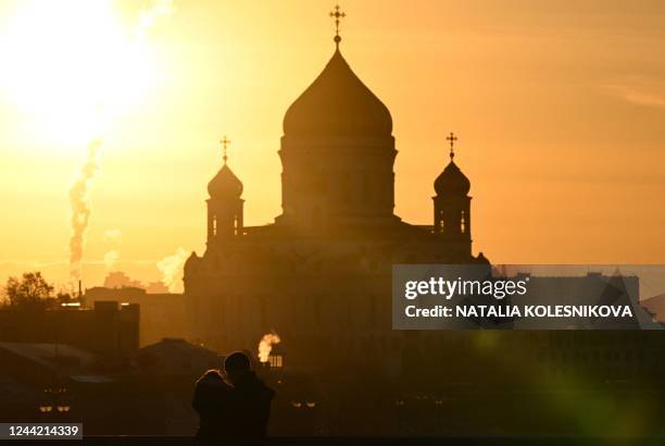 Couple shares a tender moment in front of the Christ the Saviour cathedral, the main Russian Orthodox church, at sunset in downtown Moscow on October...