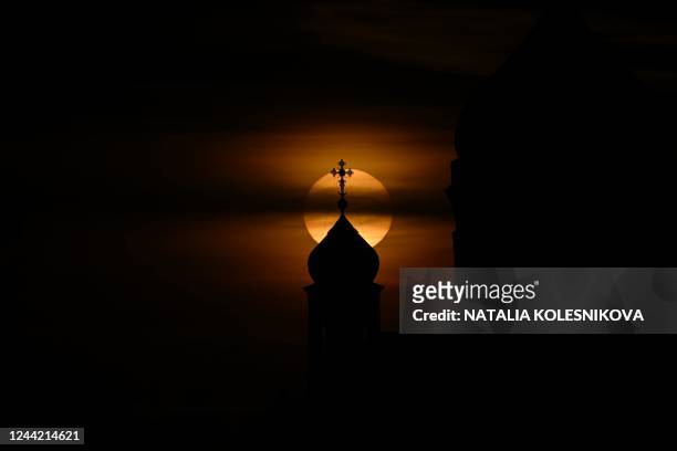 The sun sets behind a dome of the Christ the Saviour cathedral, the main Russian Orthodox church, in downtown Moscow on October 25, 2022.