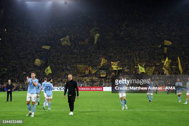 Pep Guardiola the head coach / manager of Manchester City and his players walk off at full time with the yellow wall behind them during the UEFA...